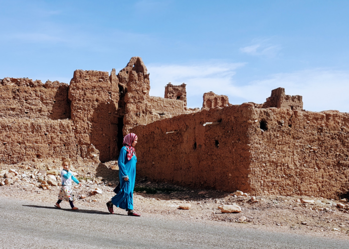 A middle eastern woman and her child walking on the street