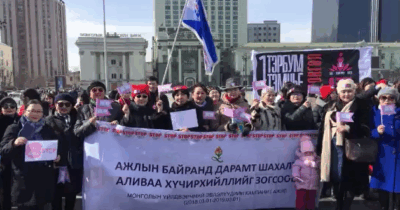 MONES SHW Coalition carrying a banner at a protest