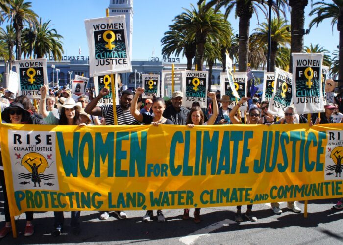 Protesters at a Women for Climate Just Rally with banners and signs