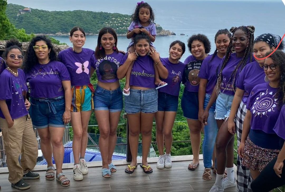 group of young women posing for photo near water