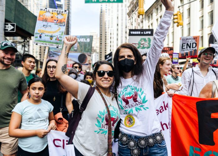 2 women raising their fists at a climate change rally