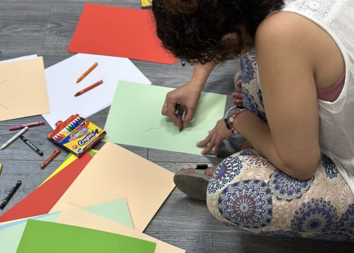 Femena participant sitting on the floor drawing at the Yara WHRD Center