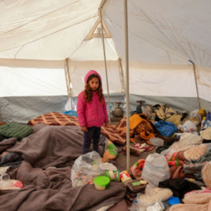 ICAN News Cover Image of a young girl in an earthquake shelter in Turkey