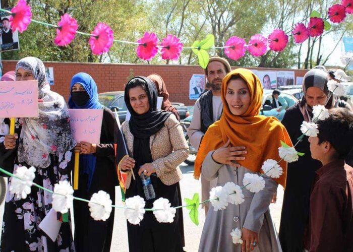 Mina's List aspiring candidates holding signs and walking at at an outdoor campaign event Afghanistan
