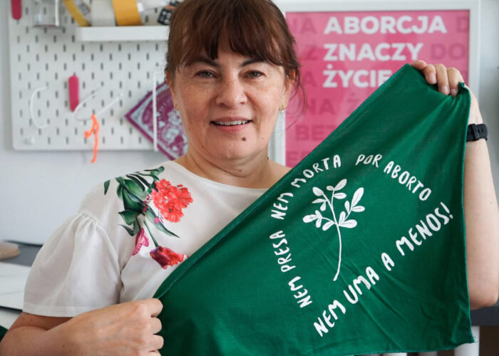 Fos Feminista participant holding a piece of green cloth with an abortion rights slogan printed on it