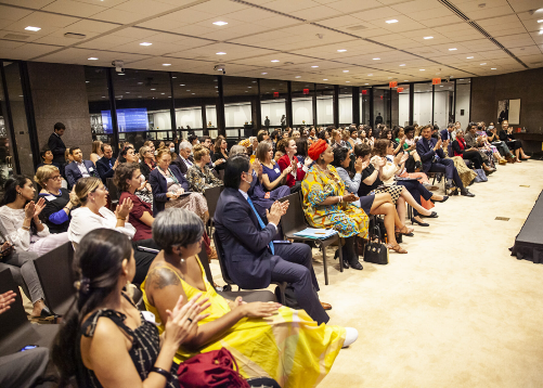 AFM page 2 Women sit in the conference audience.