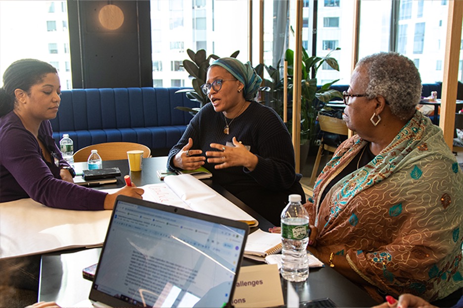 Three women converse in conference room