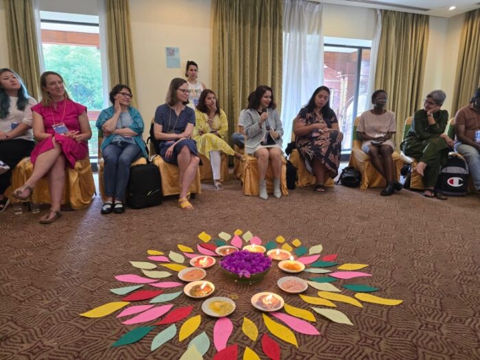 Members gather around candle and flower centerpiece for the retreat.