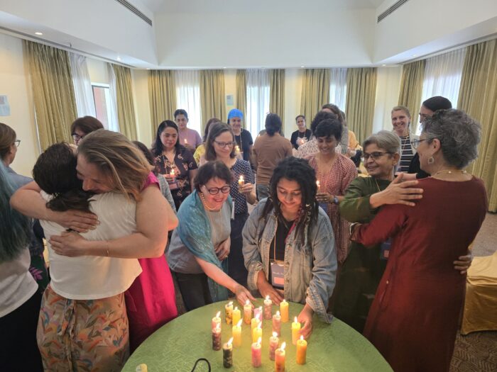 Participants gather around a table of candles