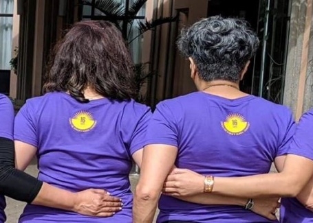 Four women with Center for Women's Global Leadership t-shirts on stand arm in arm