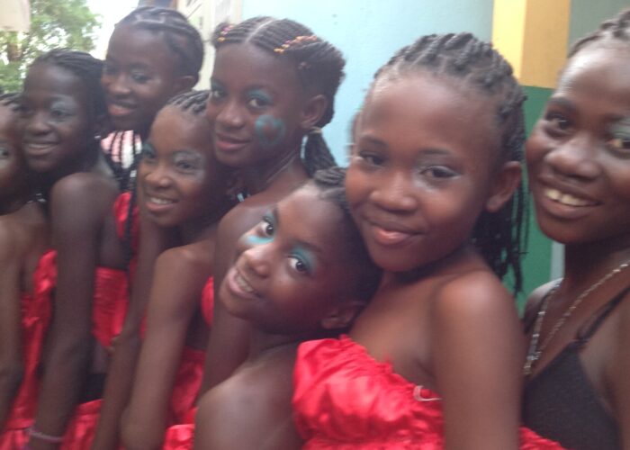 Haitian girls stand smiling in a line