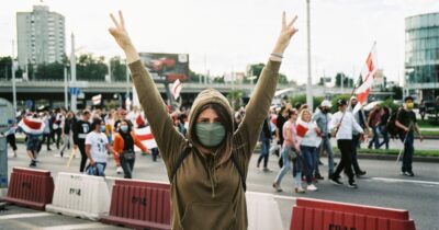 Woman protestor holds up symbols for peace